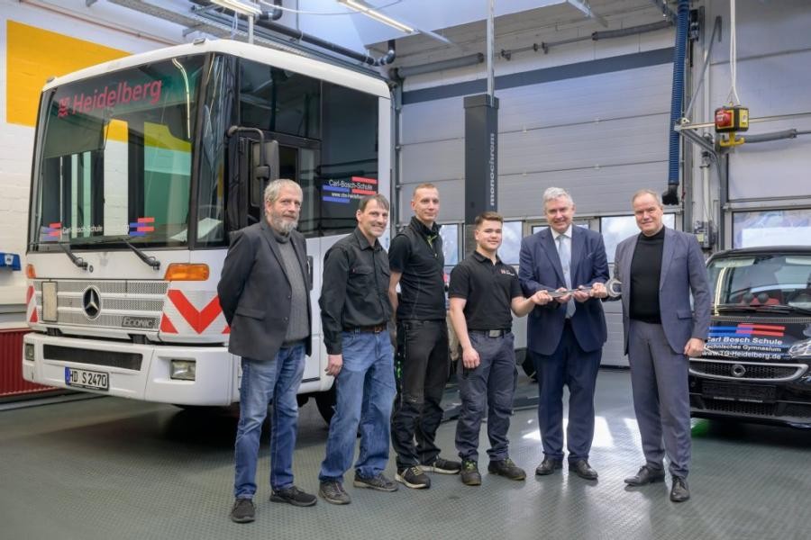 Übergabe des Lehr-LKW an die Carl-Bosch-Schule: (v.l.n.r.) Peter Schädel, Stefan Pätzhorn, Lukas Heid, Auszubildender Robert Ruf, Schulleiter J.-P. Misch und Oberbürgermeister Prof. Dr. Eckart Würzner, der symbolisch das Fahrzeug für die Stadt Heidelberg übergab, freuen sich über die Spende der ASZ Heidelberg zur Förderung der praxisnahen Ausbildung am Standort Heidelberg. Beteiligte der Stadt Heidelberg und Carl-Bosch-Schule stehen vor dem Lehr-LKW