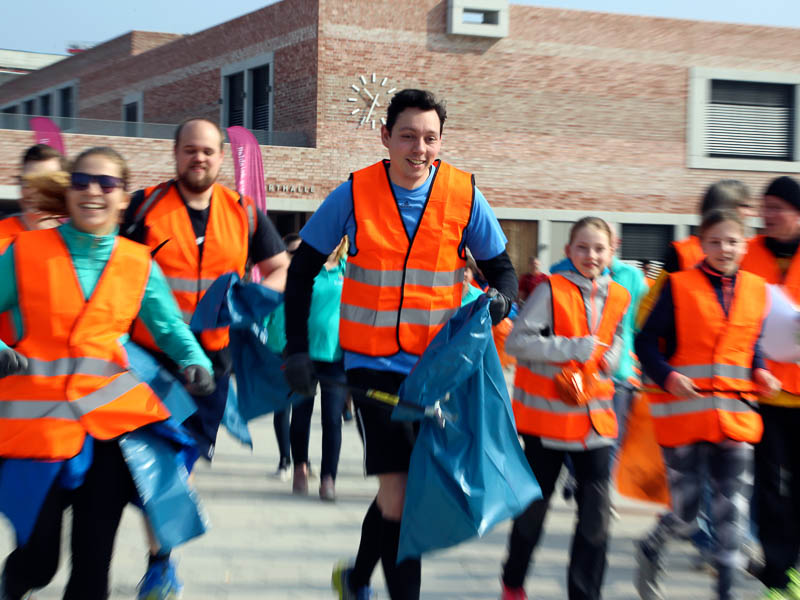 Zwei Müllwerker vor einem Abfallfahrzeug.