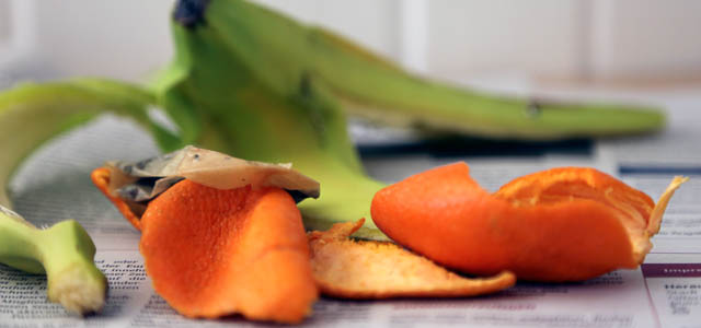 Mandarinenschalen und Bananenschalen liegen auf einer Zeitung