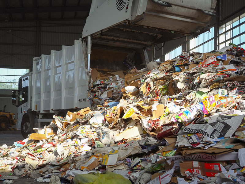 Zwei Müllwerker vor einem Abfallfahrzeug.