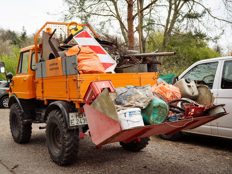 Zwei Müllwerker vor einem Abfallfahrzeug.